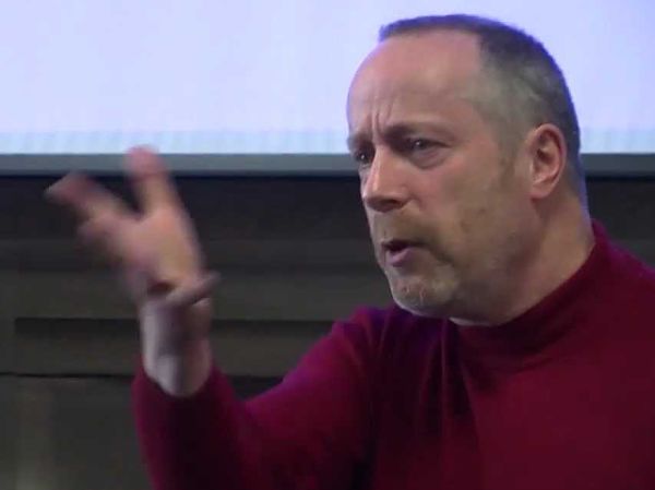 Photo of Steve Reicher in a red jumper giving a lecture